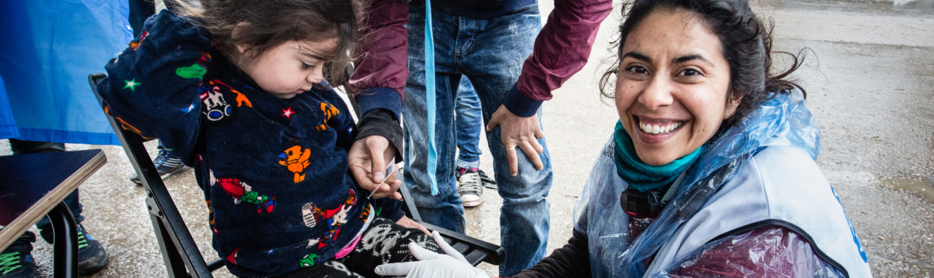 Une bénévole aide une petite fille dans les Balkans
