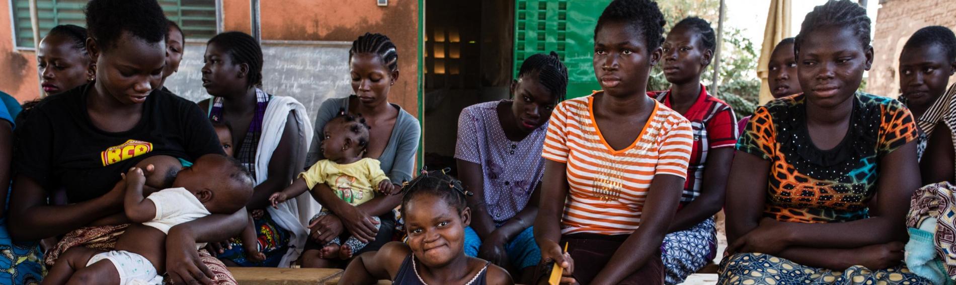 Un groupe d'enfants Burkinabés - des garçons et des filles de tous âges - sont assis face à l'objectif.