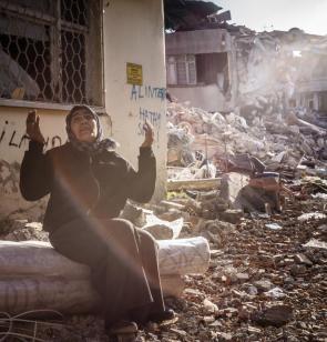 Femme implorant dieu dans une rue de Defne (Hatay) au pied de sa maison détruite. ©Olivier Papegnies, 2023, Turquie.