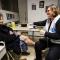 Dans un centre d'accueil du Plan hiver, une béénvoles de Médecins du Monde examine la jambe d'une dame enveloppée dans un épais manteau noir.